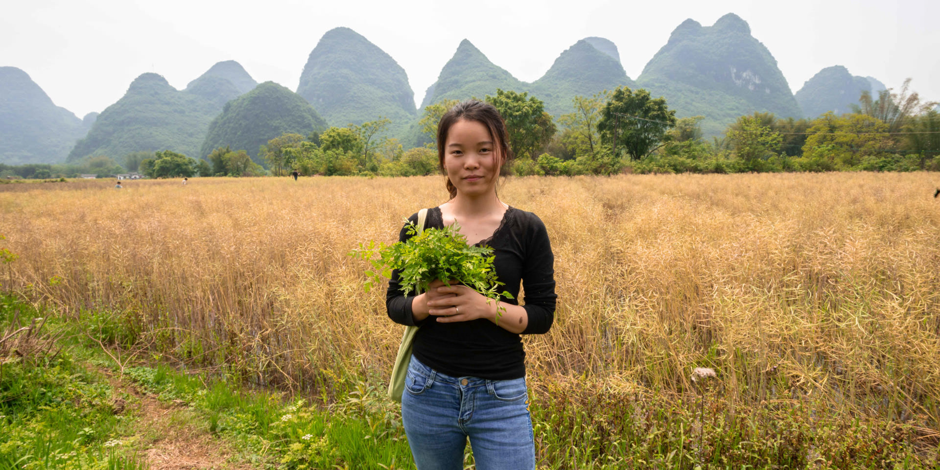 Ella and her wild veg A young woman holds a handful of wild vegetables